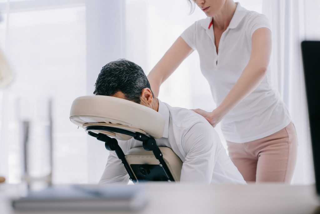 masseuse doing seated massage for businessman